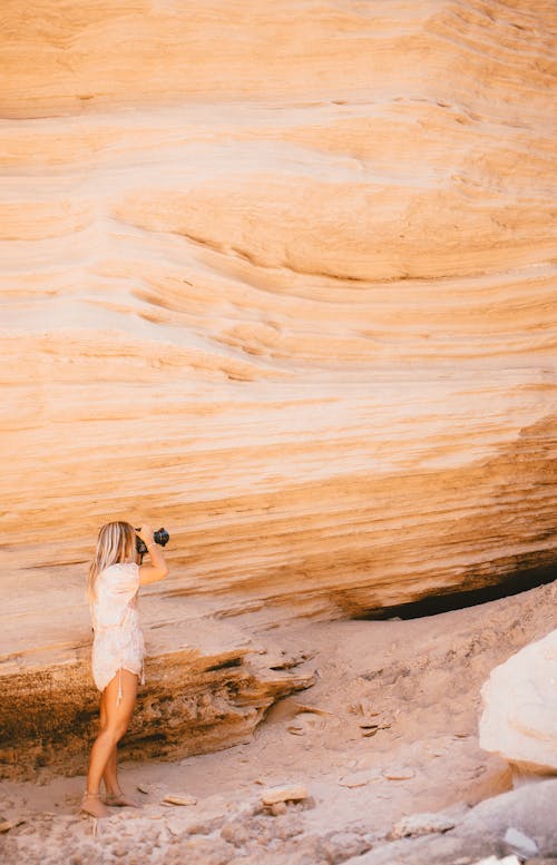 A Woman Taking a Picture of a Natural Rock Formation