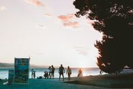 A serene beach scene with people enjoying a sunset walk along the shoreline.