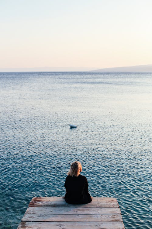 A Person Sitting Alone on Dock