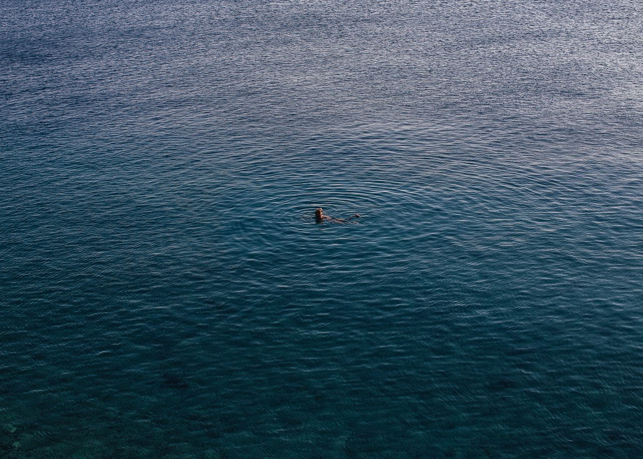 Lone swimmer in turquoise open ocean water, photo by Rachel Claire on Pexels