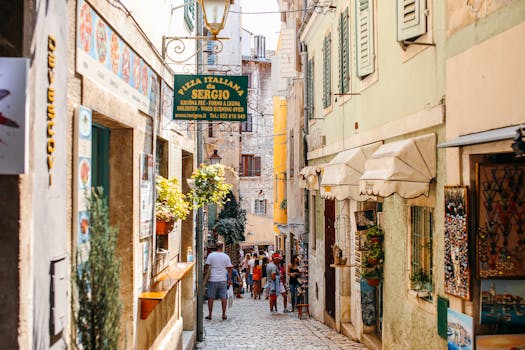 Charming Italian alleyway bustling with people and vibrant shops on a sunny day.