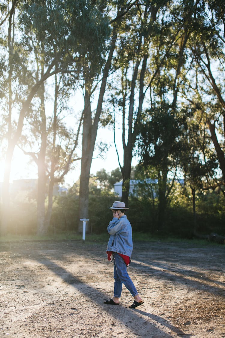 A Person Walking At A Park While Talking On The Phone