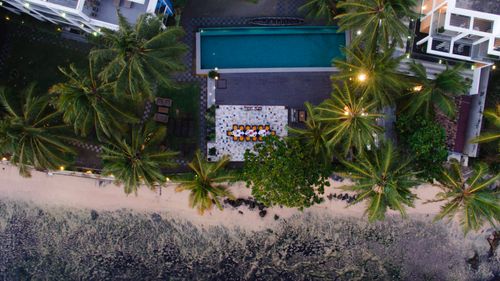 Free Stunning aerial shot of a tropical resort featuring a beachfront pool surrounded by palm trees. Stock Photo