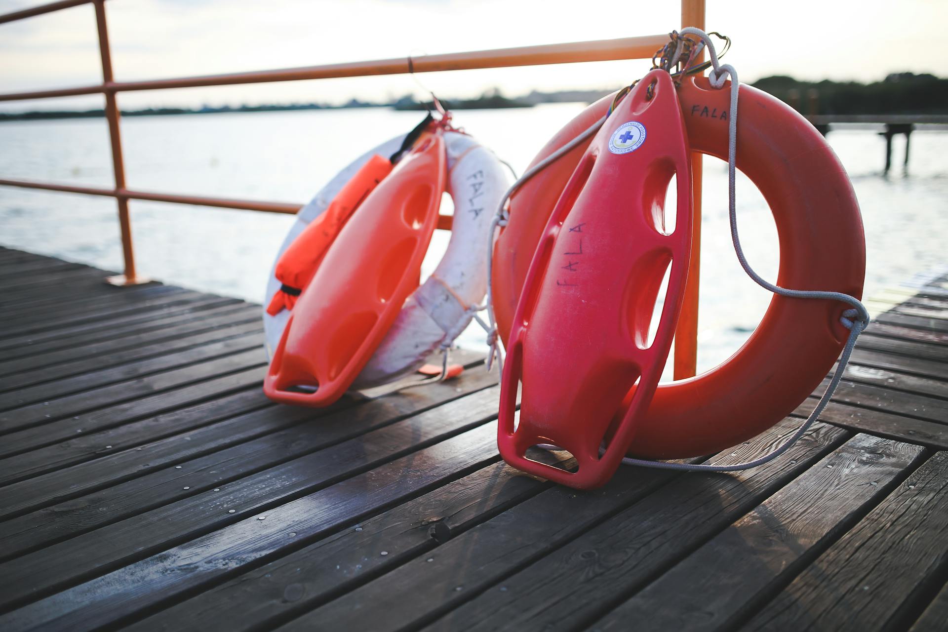 Close-up of lifebuoys and safety equipment on a lake dock providing serene waterside ambiance.