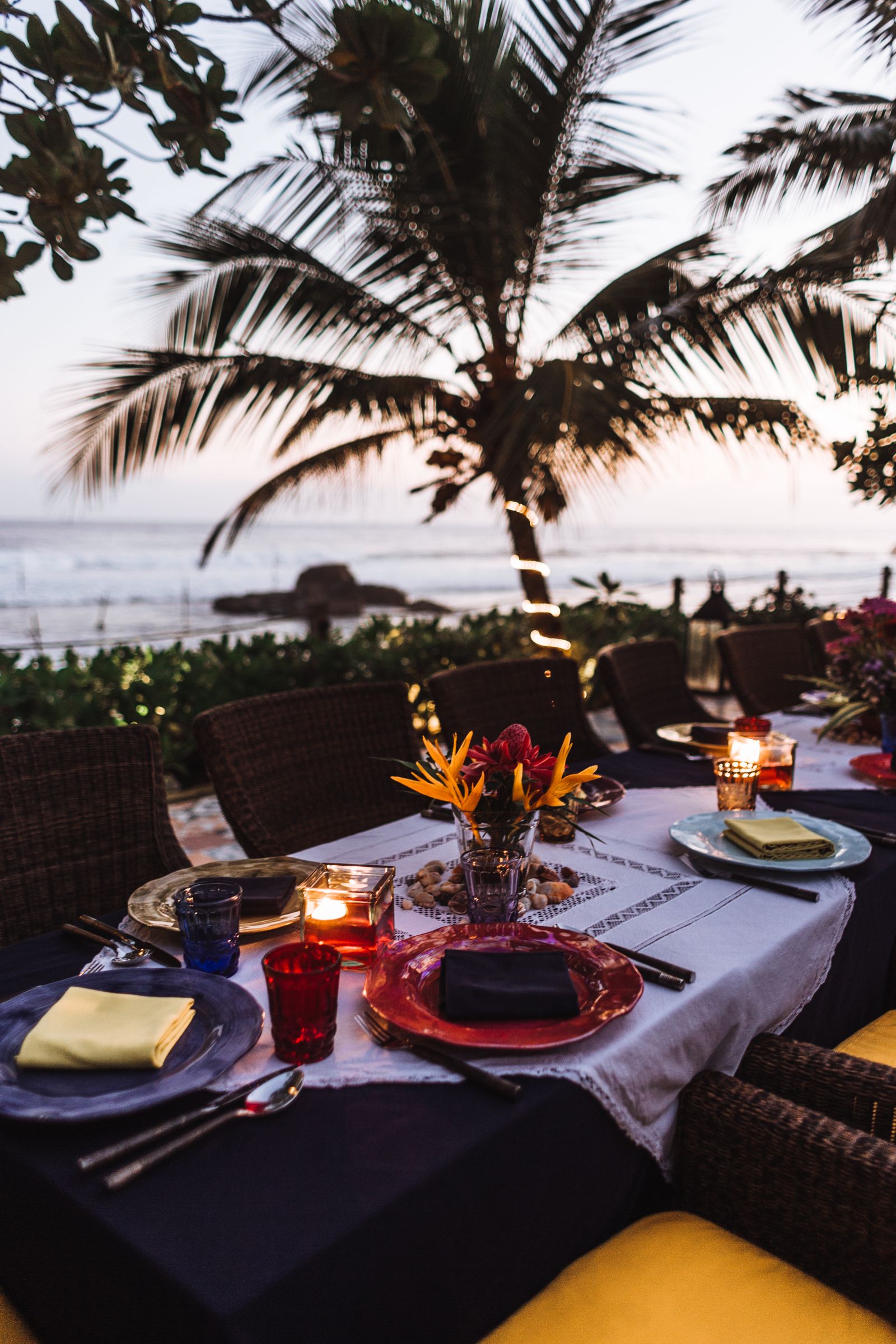 Long candlelit seaside table dressed for an evening meal.