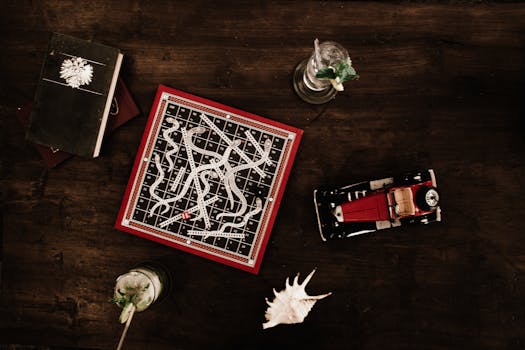 Overhead view of a vintage board game setup with drinks and decor on a wooden surface.