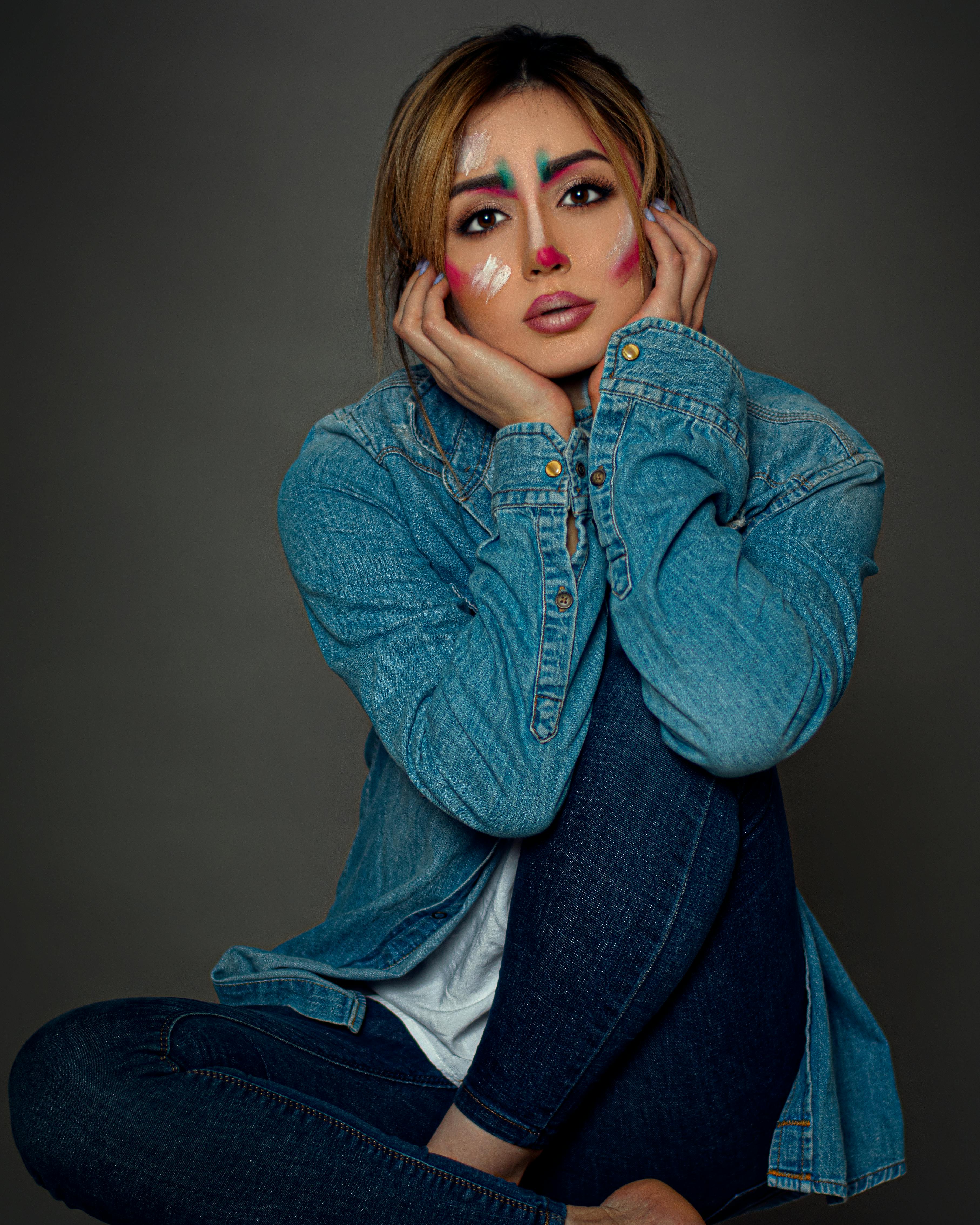 woman in blue denim jacket posing with her hands under her chin