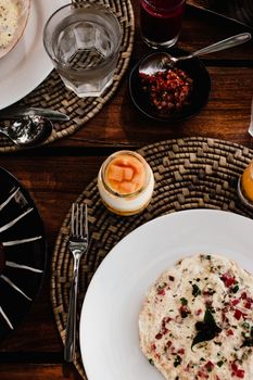 Elegant top view of a gourmet breakfast with utensils on a textured table mat.
