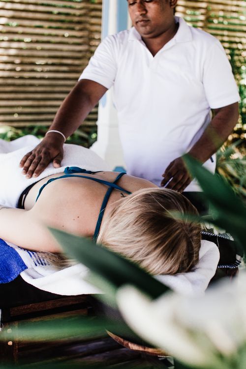 Free A woman enjoying a massage therapy session by a trained therapist indoors. Stock Photo