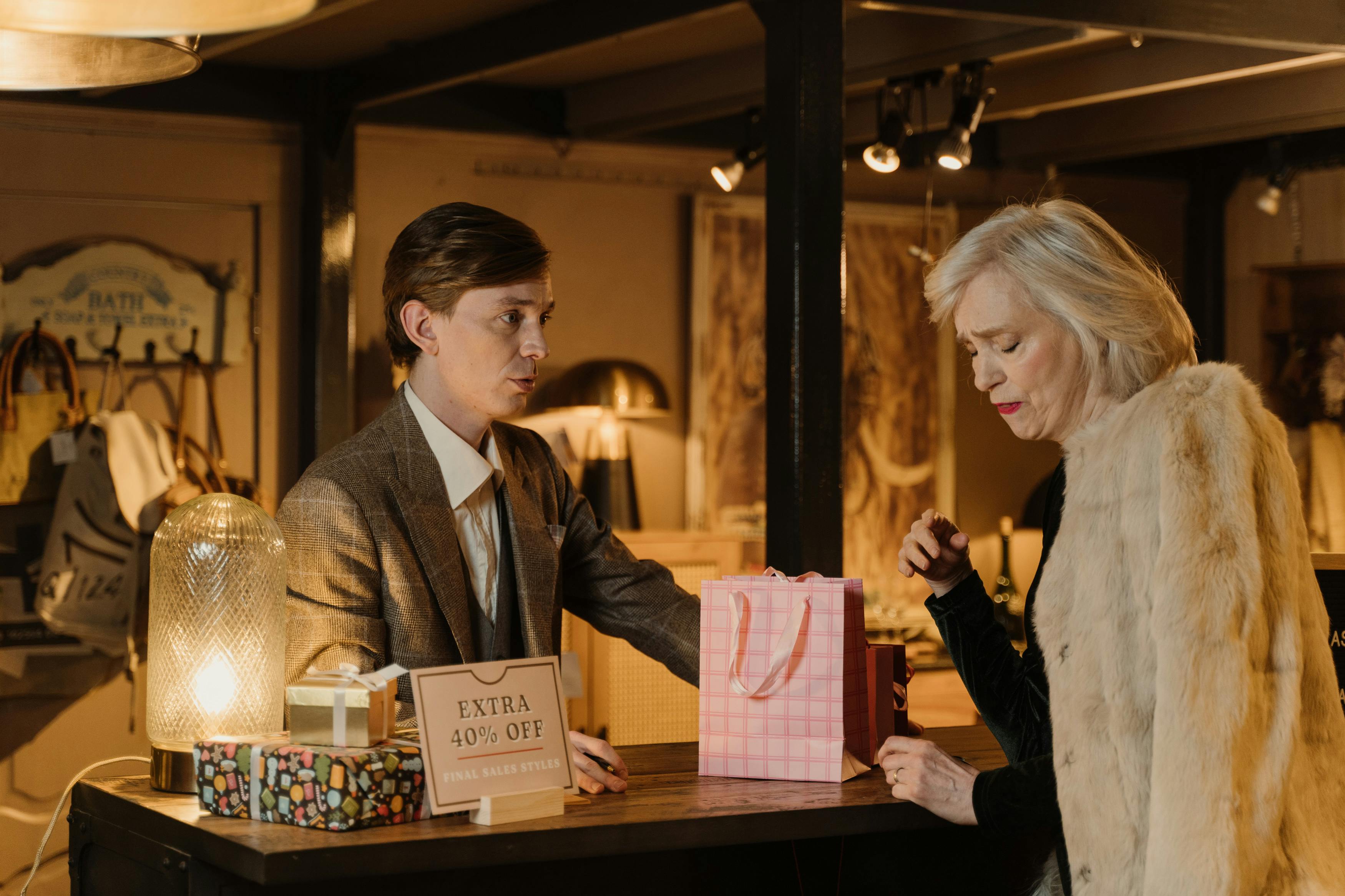 a salesman talking to a woman wearing a fur coat