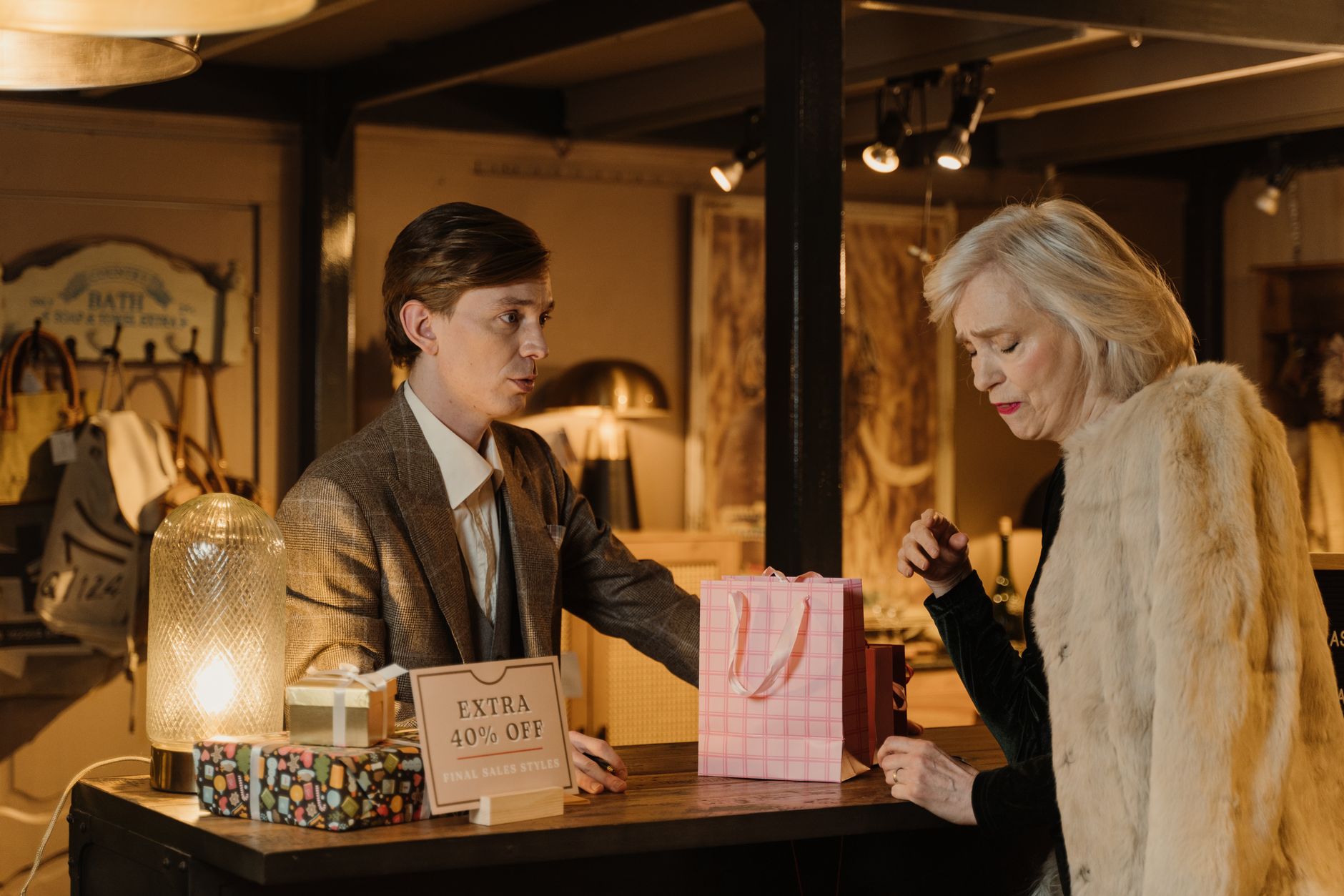 Elegant shoppers engage in a conversation in a chic boutique, showcasing luxury retail ambiance.