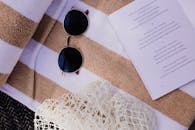 舒适的布置，包括书、太阳镜和条纹毛巾，非常适合海滩旅行