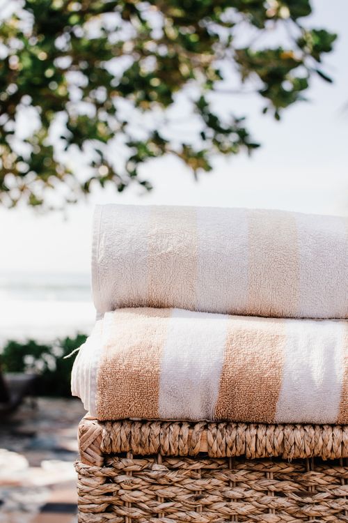 Free Two stacked bath towels in a wicker basket with outdoor natural background. Stock Photo