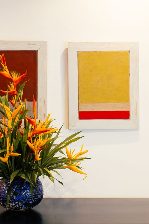 Free A colorful flower arrangement in a vase next to abstract paintings on a wall, creating a vivid indoor scene. Stock Photo