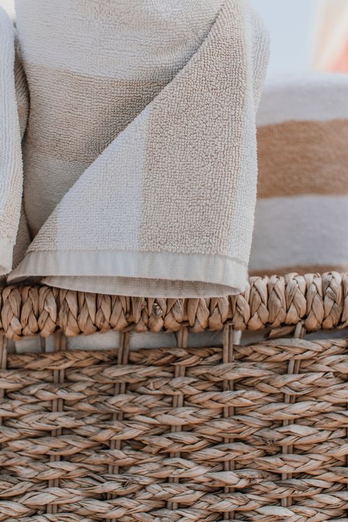 Free Close-up of beige cotton bath towels in a woven basket, highlighting texture. Stock Photo