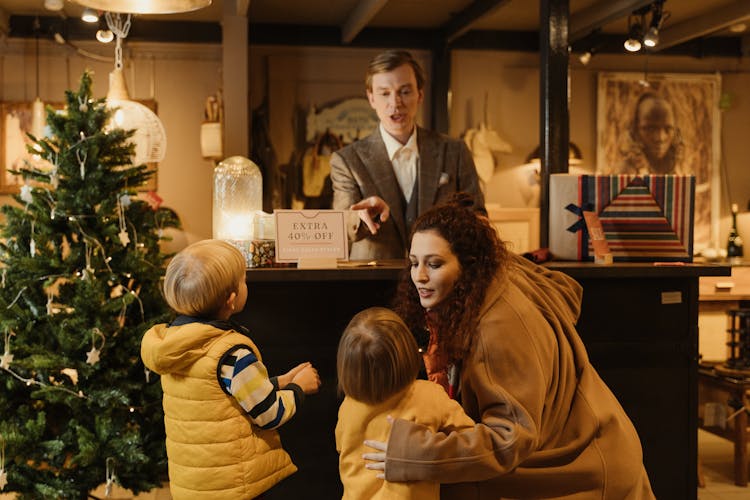 A Store Manager Serving A Family Inside The Store