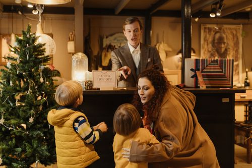 Free A family shopping during the holiday season with children near a Christmas tree seeking great deals. Stock Photo