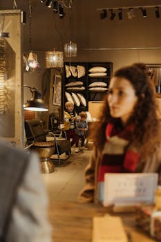 A mother with children browsing in a cozy furniture store filled with pillows and decor.