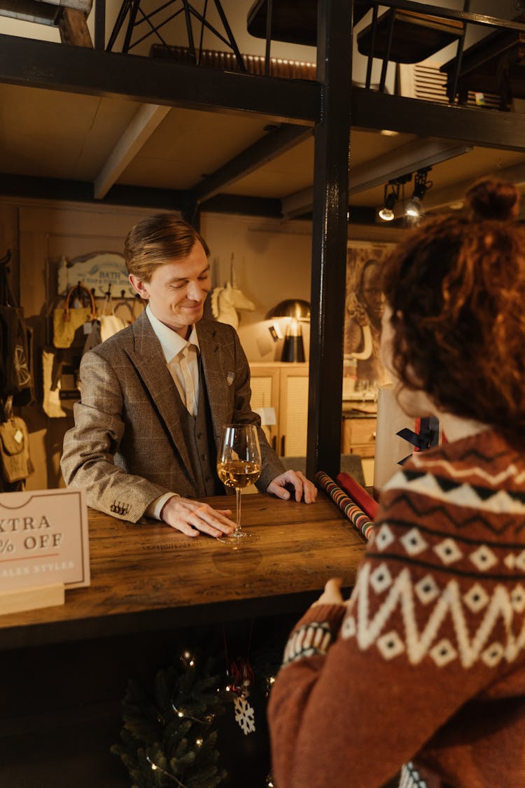 A Salesman Offering A Glass Of Wine To The Person