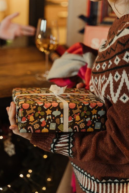 Free A person holding a decorated Christmas gift box, capturing the festive spirit indoors. Stock Photo