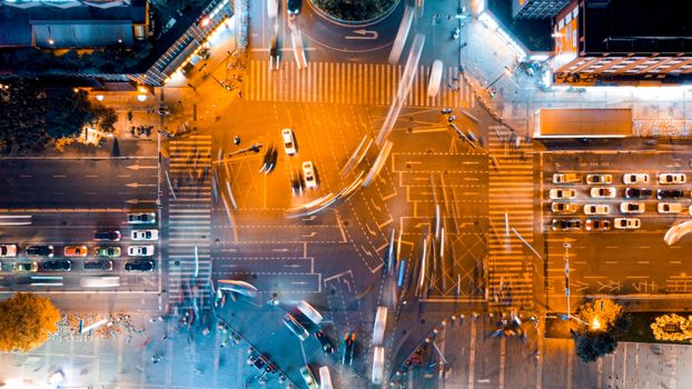 Dynamic aerial shot of vibrant city traffic at night capturing light trails and bustling activity.