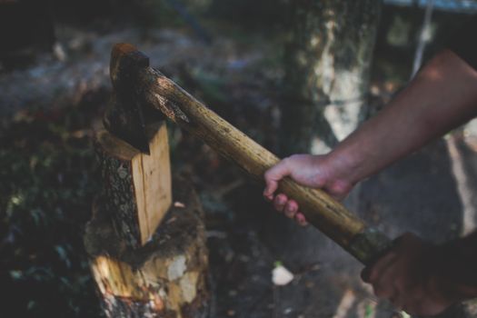 A man holds an old, worn axe