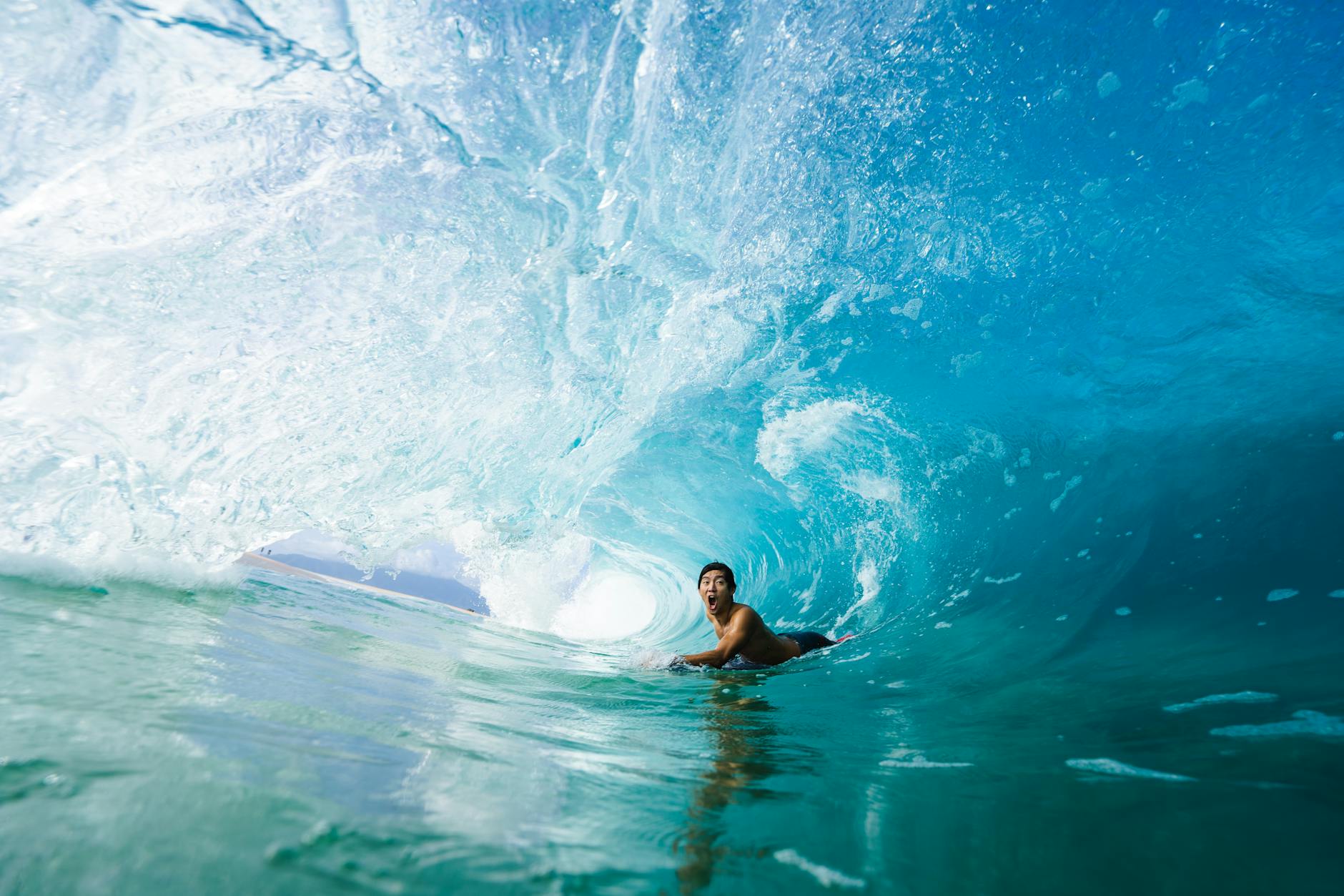 Thrilling shot of a surfer riding a wave barrel in Hawaii, capturing the essence of extreme water sports.