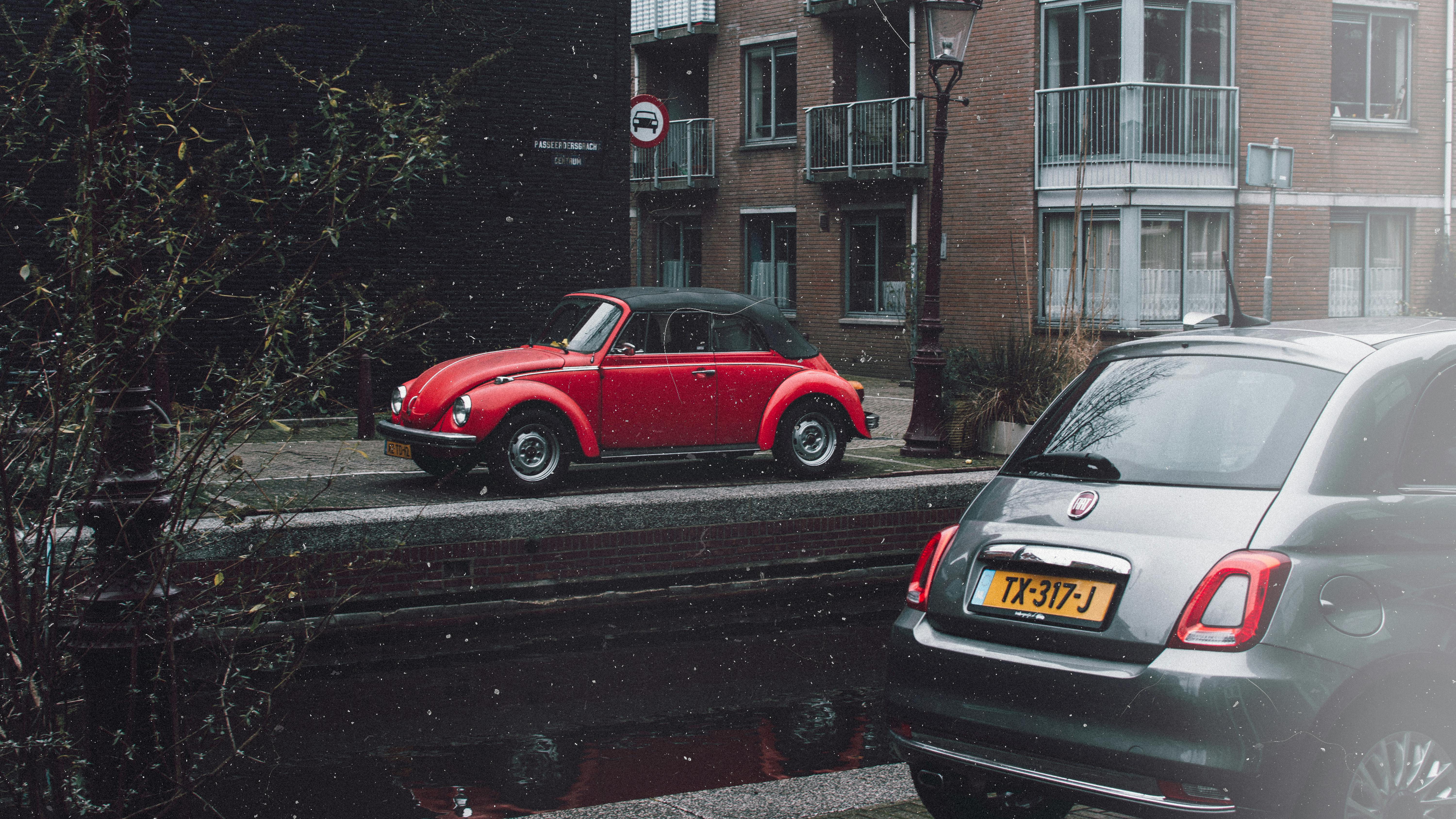 Red Volkswagen Beetle Parked On Sidewalk · Free Stock Photo