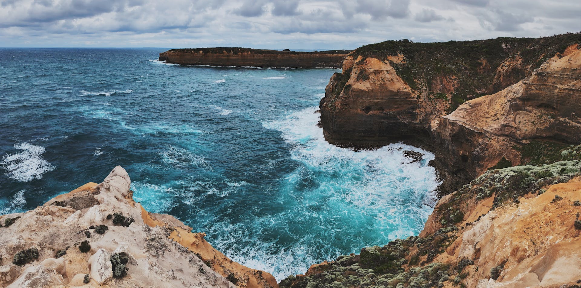 Dramatic coastal cliffs and ocean waves at Loch Ard Gorge in Port Campbell, Australia.