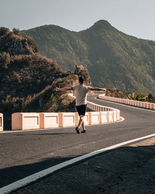 Man Walking on Mountain Road