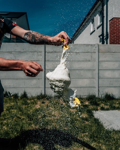 A Person Popping a Balloon with Milk