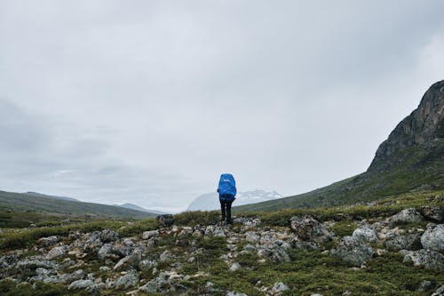 Unrecognizable Person with Backpack Climbing Mountain