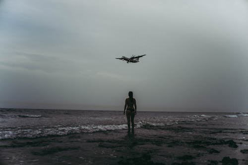 女人在海边的灰度摄影