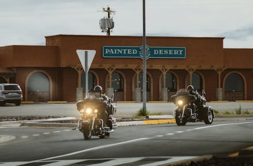 Two Men Riding on Touring Motorcycle Near Painted Desert Store