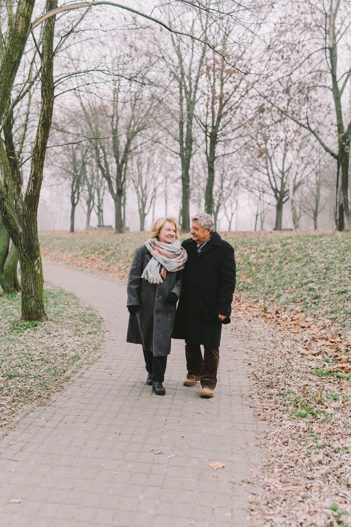Coppia adulta a passeggio in un parco autunnale; fotografia illustrativa