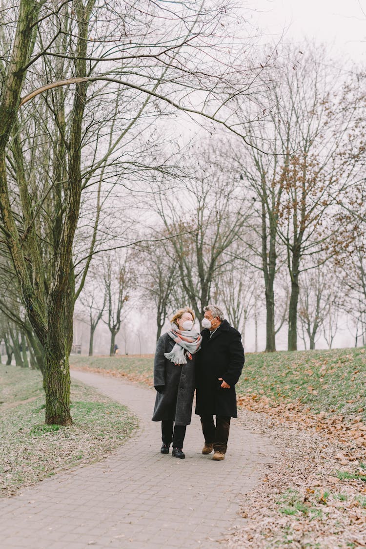 Man And Woman Walking On The Pathway In The Park