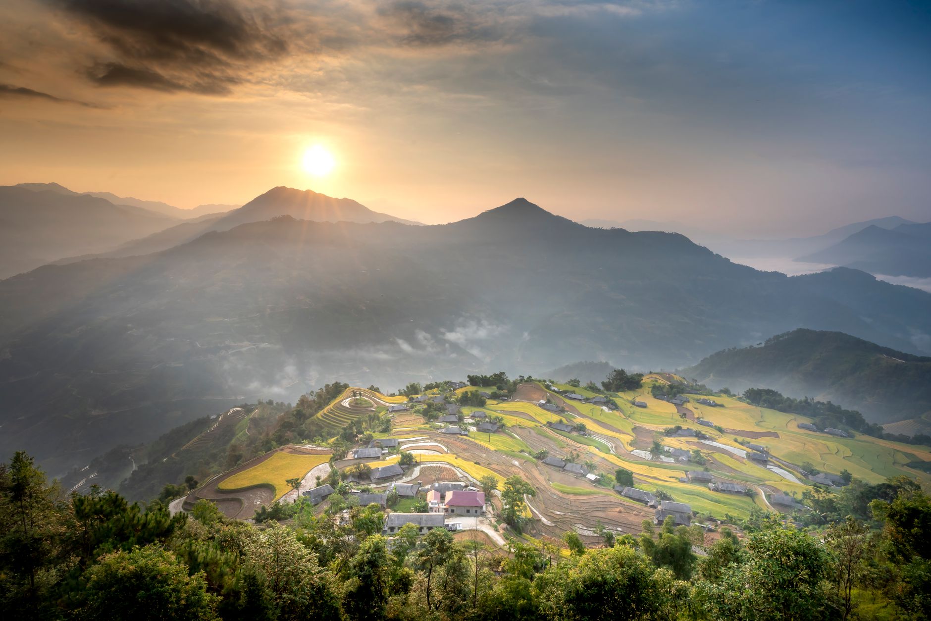 Amazing scenery of vast hill terrain with remote small village and verdant plantation on hilltop on clear weather