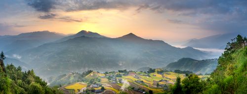 Free Picturesque scenery of spacious forested highlands with small village surrounded by lush greenery and fields under majestic sunrise sky Stock Photo
