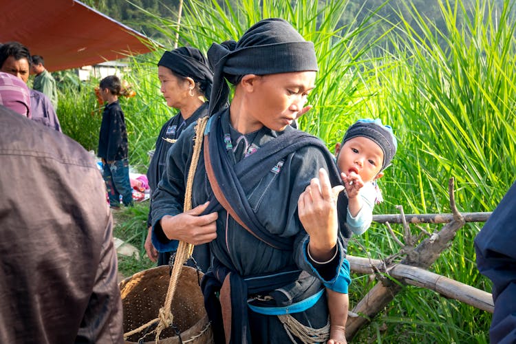 Asian Female Cotton Picker Carrying Baby On Back