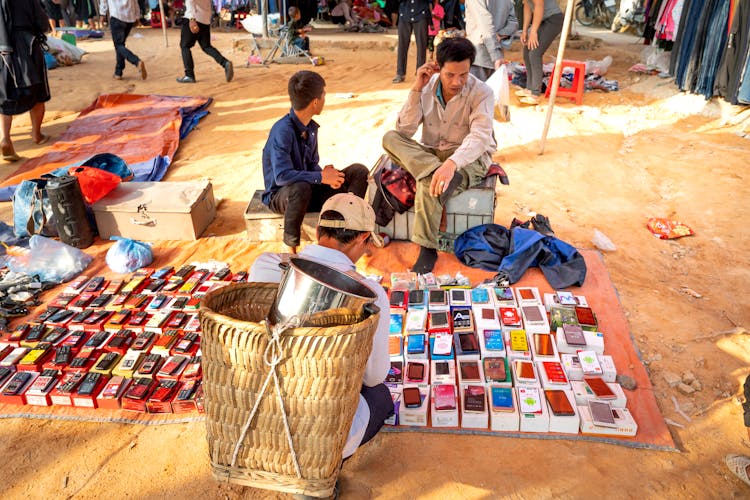 Ethnic Men Selling Mobile Phones On Local Street Market