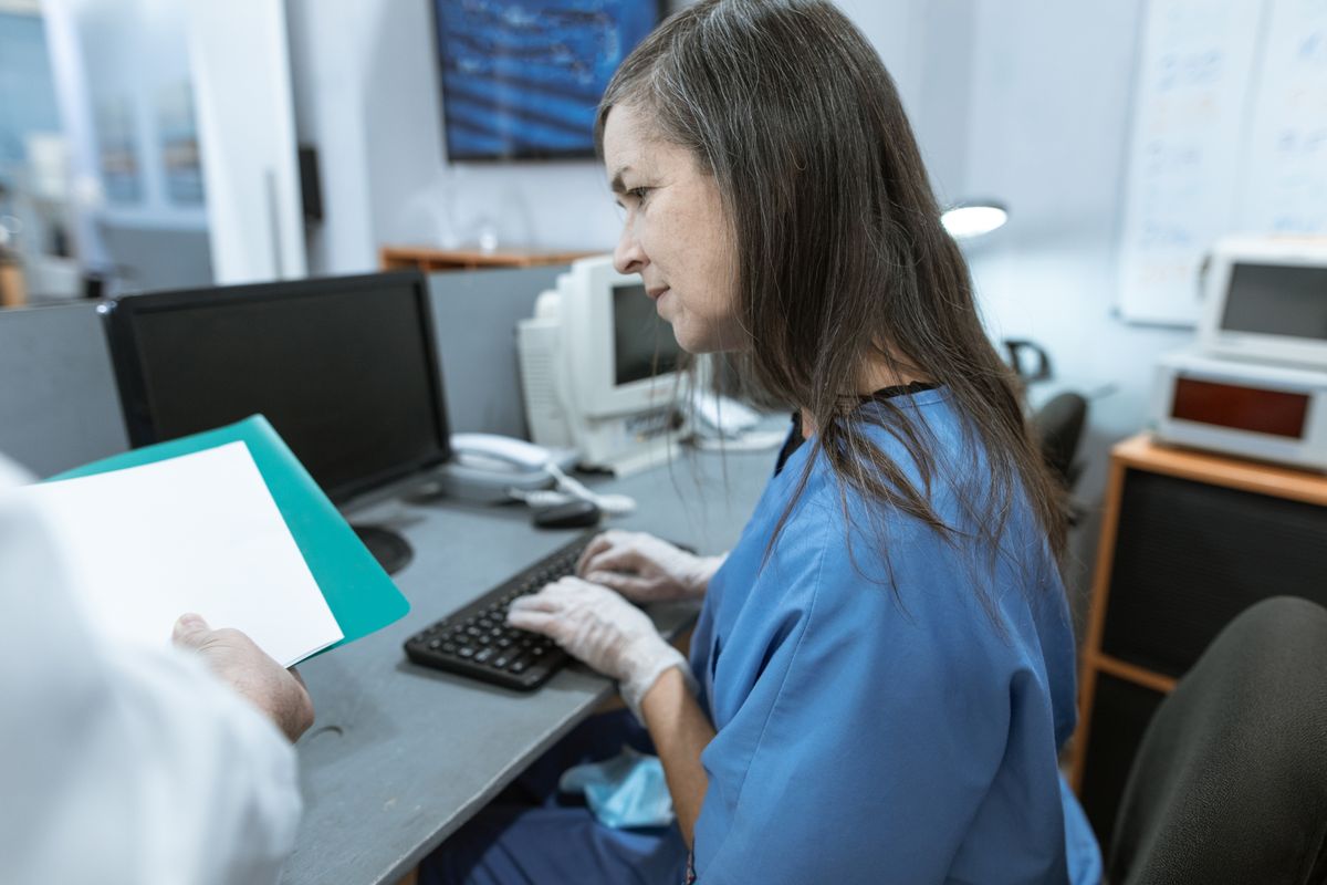 ممرضة تكتب على لوحة المفاتيح في محطة عمل طبية