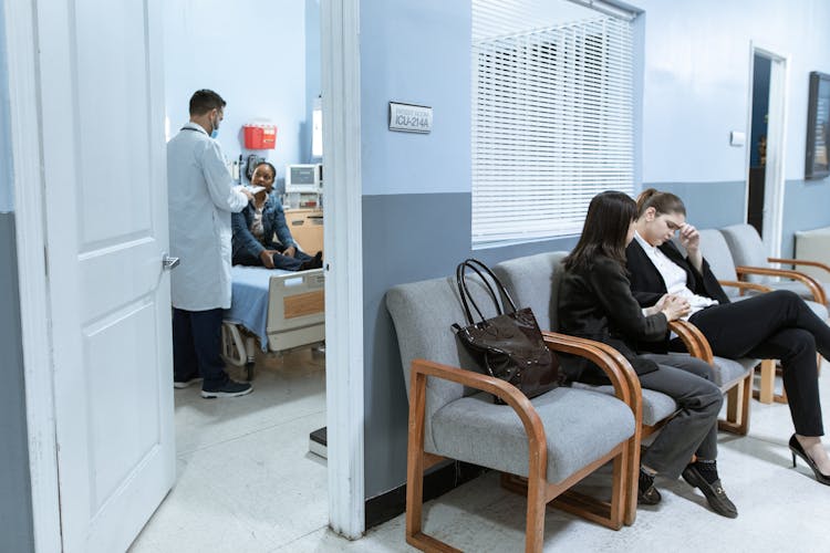 A Woman Comforting Another Woman In A Hospital