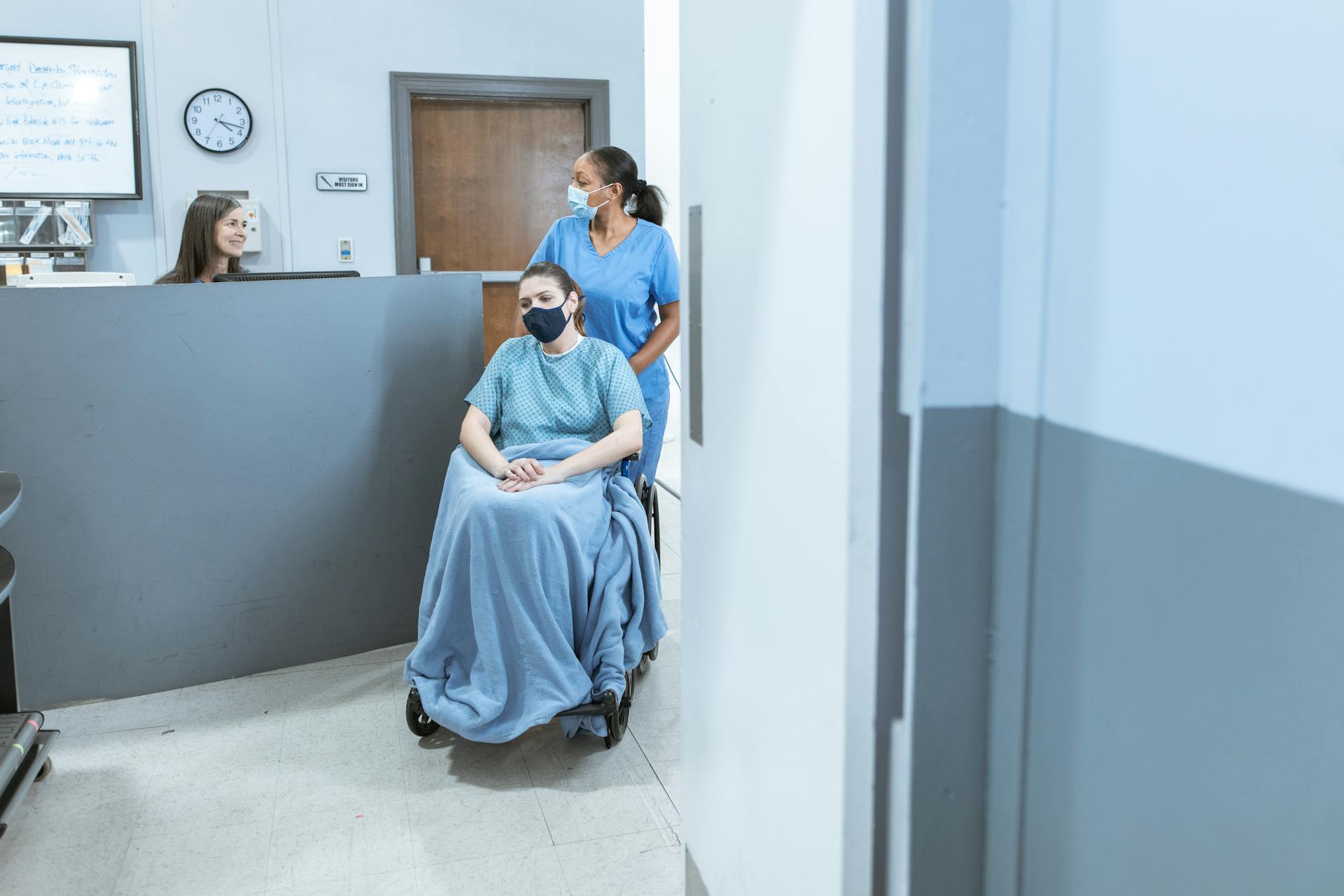 Nurse Assisting a Patient Sitting on a Wheelchair