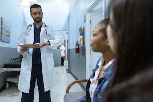 Free Man in White Medical Scrub Suit Standing Beside Girl in Blue Denim Jacket Stock Photo