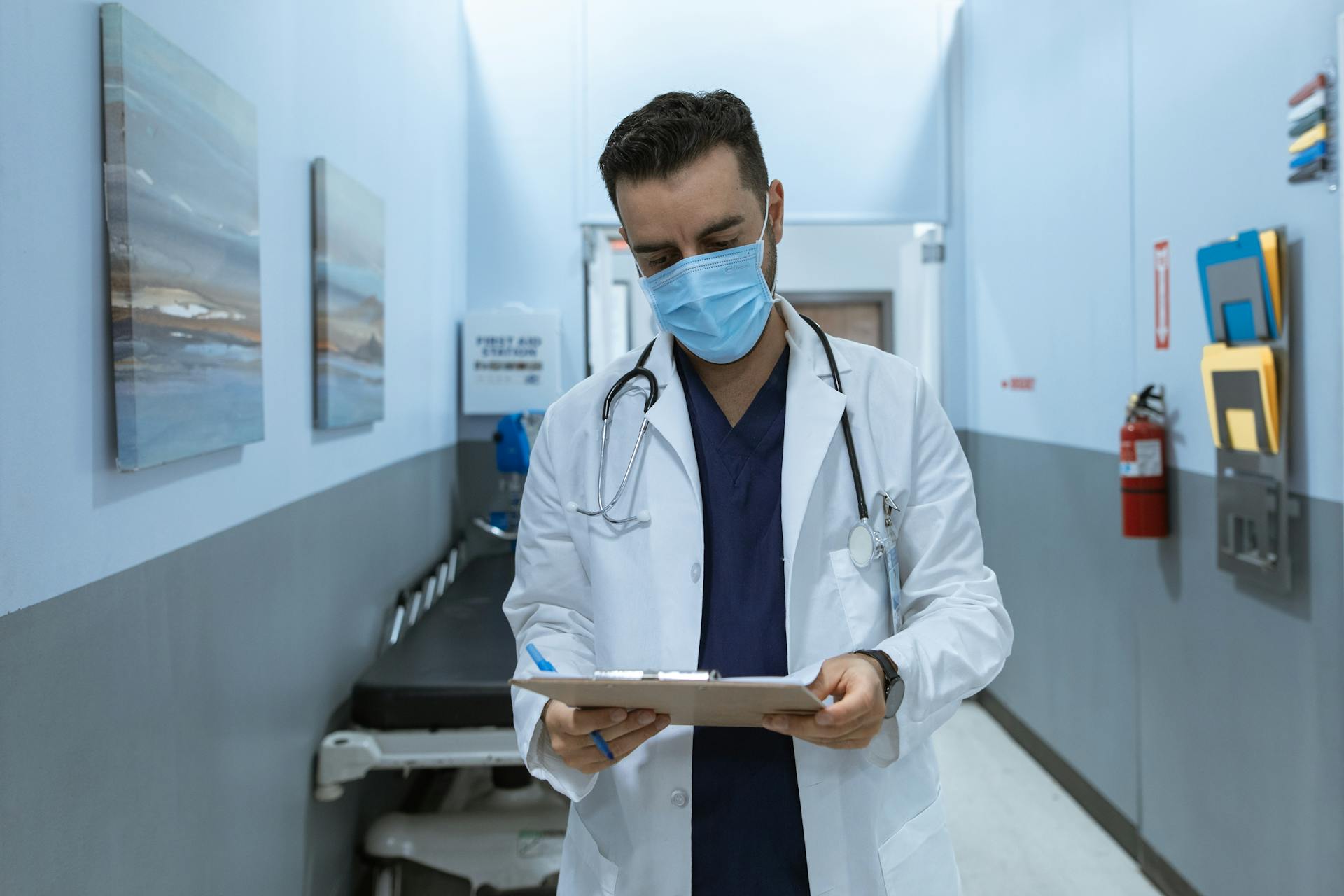 A healthcare professional reviewing medical charts in a hospital corridor, emphasizing safety and professionalism.