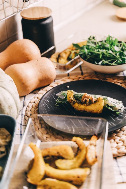 Free A cozy kitchen scene featuring squash and fresh arugula on a rustic counter, evoking autumn vibes. Stock Photo