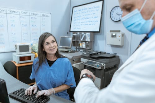Nurse Smiling while Looking at a Doctor
