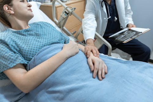 Free Doctor Touching the Arm of a Patient Stock Photo