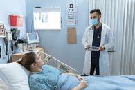 Doctor Talking to a Patient Lying Down on a Hospital Bed