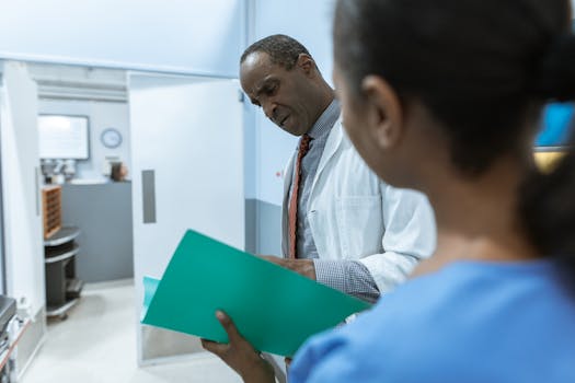 Doctors examining a folder in a hospital setting, highlighting teamwork and healthcare professionalism.